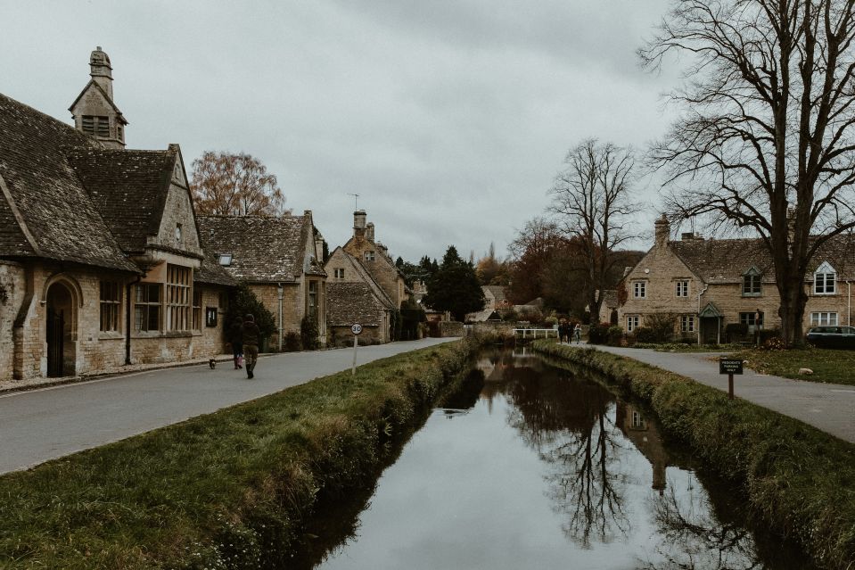 Couple walking through scenic Cotswolds village street