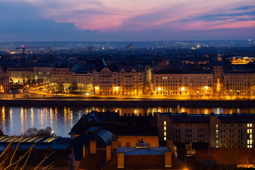 Luxury hotel views overlooking the Danube River and historic Budapest skyline at sunset.