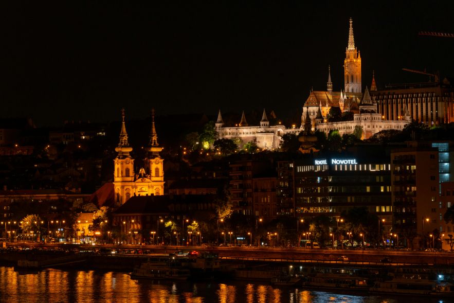 Couple relaxing on a luxury hotel terrace overlooking Budapest during sunset.