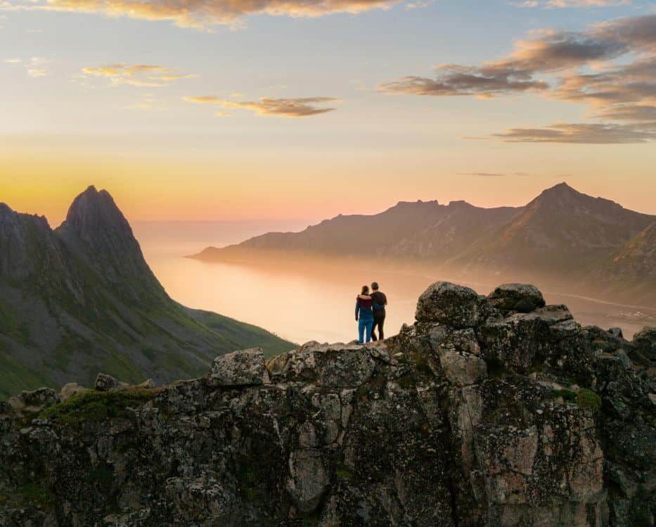 Couple sharing a romantic sunset view over the Norwegian fjords