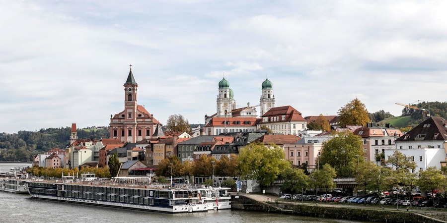 [Comparison of a quiet Danube river cruise lounge and a large ocean cruise ship atrium]